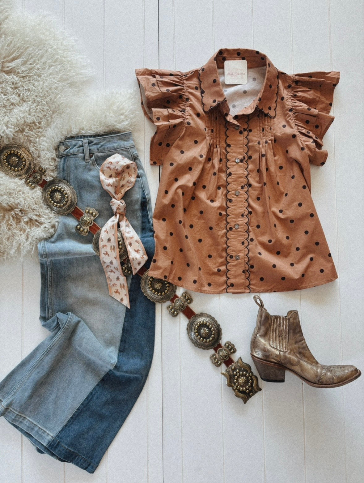 A brown polka dot blouse with ruffled sleeves