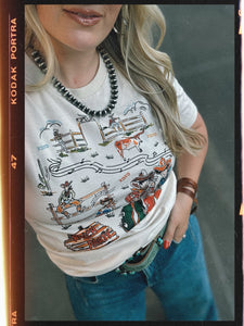 Person wearing a white t-shirt with a graphic design, standing against a neutral background.