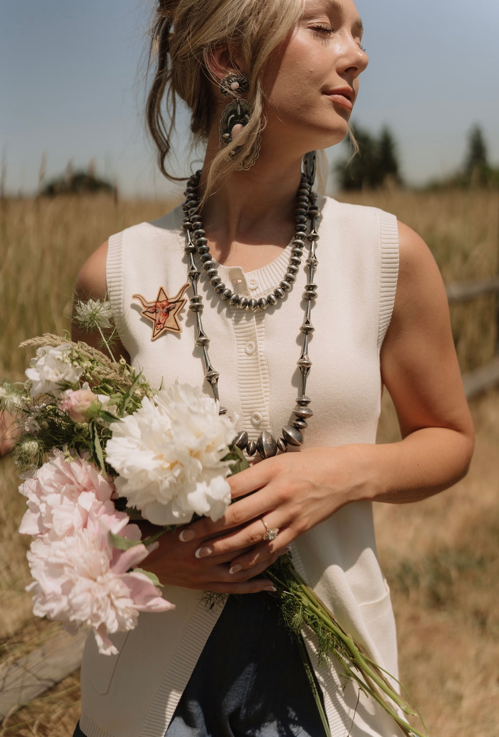 Woman holding a bouquet of flowers in a field