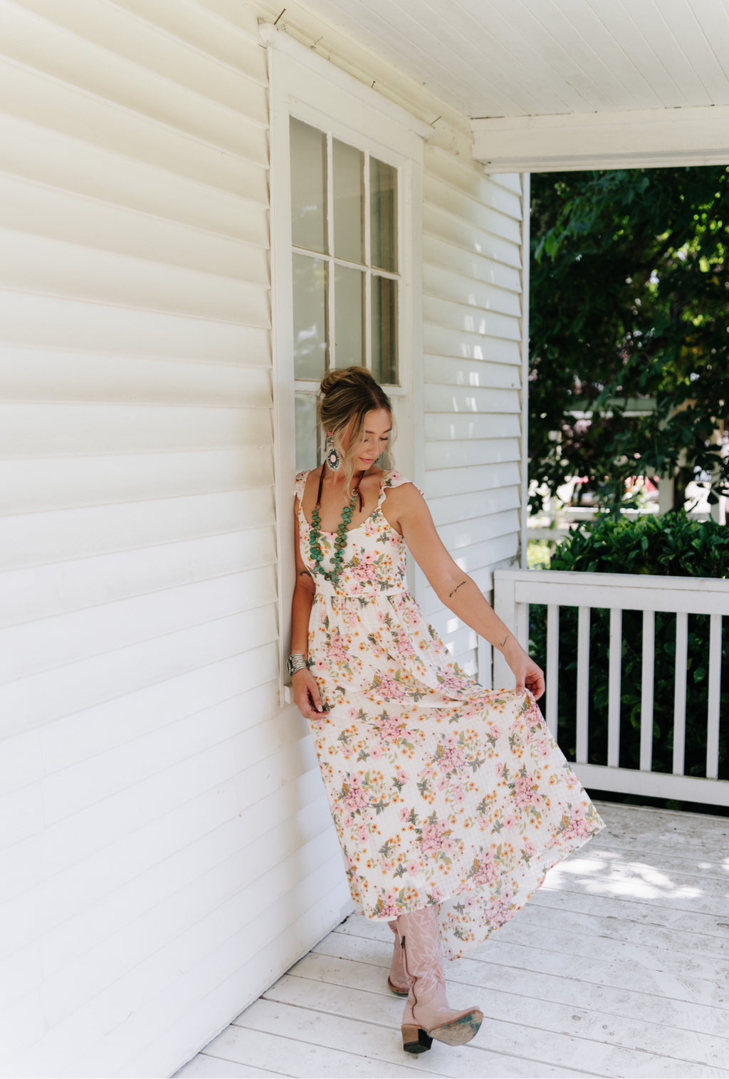 Woman in a floral dress standing on a porch