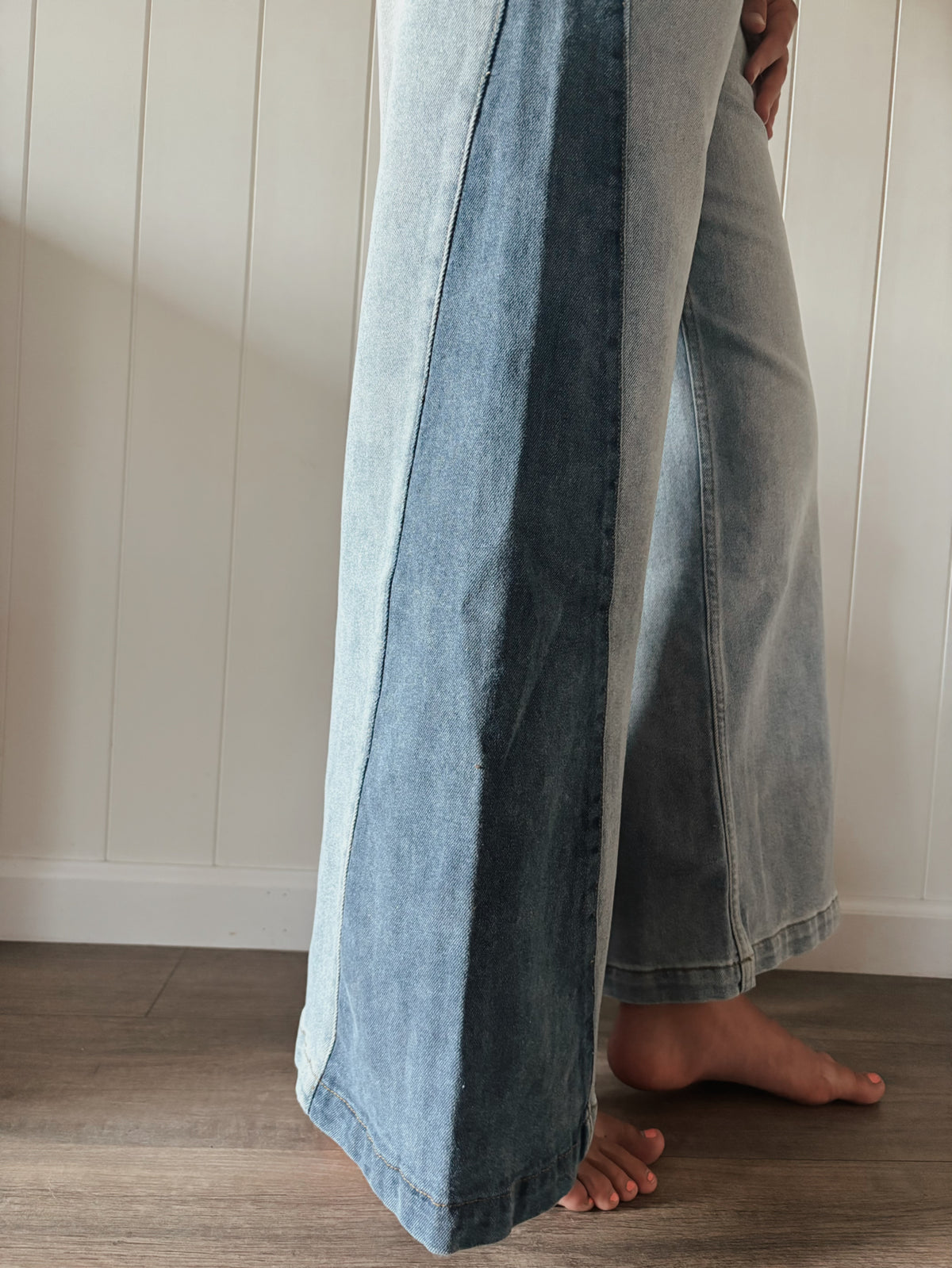 Wide-leg two-tone denim jeans seen from the side